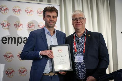 Nathan Maddock holding Fellowship award next to Sam Rossiter-Stead