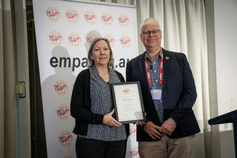 Mel Taylor holding Fellowship award standing next to Sam Rossiter-Stead