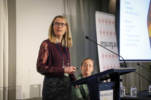 Erica Kuligowski standing at lecturn presenting