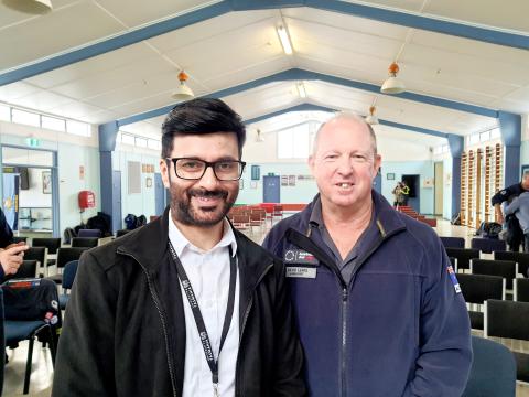 Adeel and another man smiling in a white room