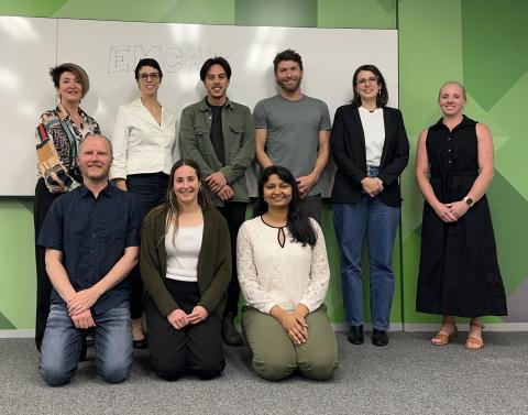 9 people gathered for a photo smiling