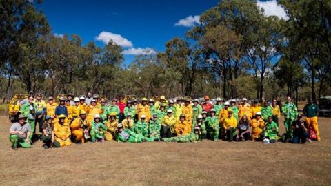 Group of people in firefighting gear gathered outside