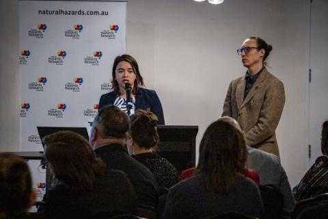 Two people presenting at lecturn in front of audience